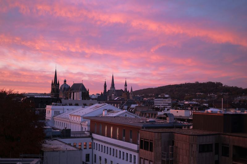 Abendhimmel über den Dächern von Aachen mit den Türmen von Dom und Rathaus
