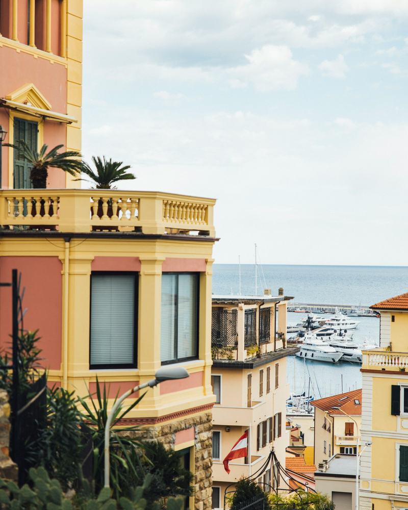 View between colourful houses onto a yacht harbour