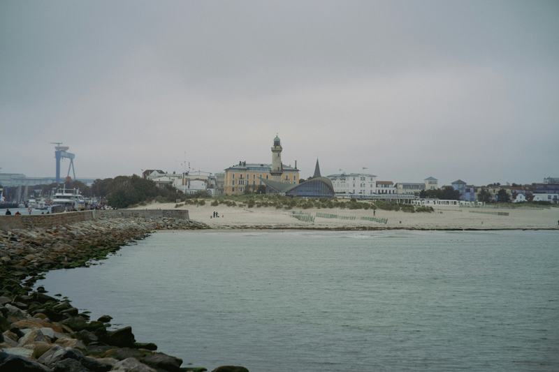 Warnemünde beach with the lighthouse and Teepott on a grey day