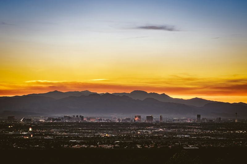 Las Vegas skyline at dusk in front of mountain ranges